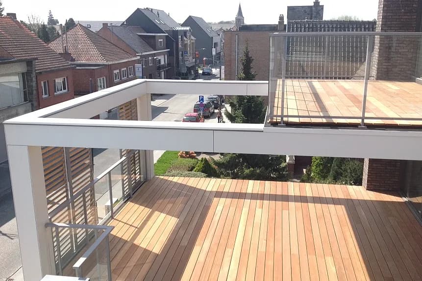 Afgewerkt houten terrasdek op een modern gebouw in Tremelo, Pharma Finance, uitgevoerd door Dakwerken De Haes.