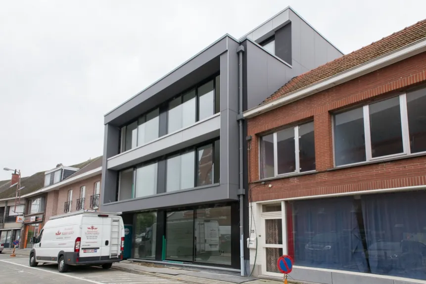 Afgewerkte gevelbekleding in grijze composietpanelen op een stadswoning in Putte, Alice Nahonstraat, uitgevoerd door Dakwerken De Haes.